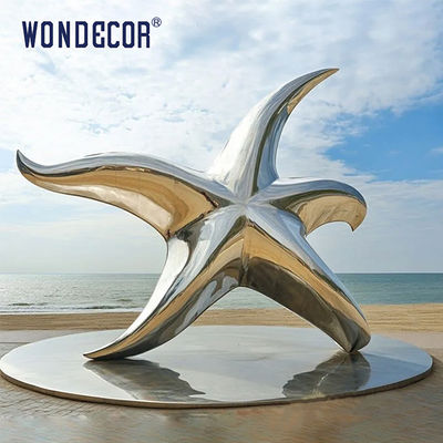 Large stainless steel star shaped outdoor sculpture in the park